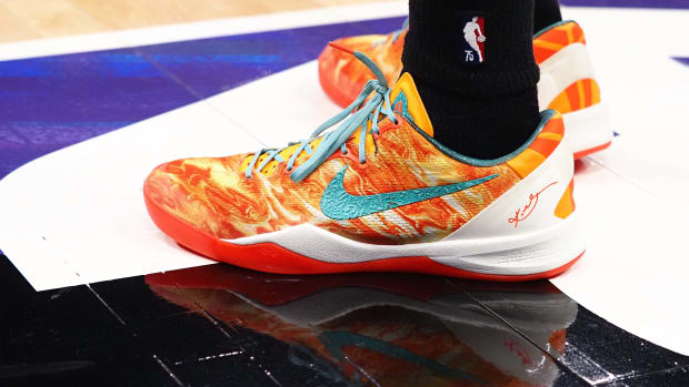 View of orange and green Nike Kobe shoes.